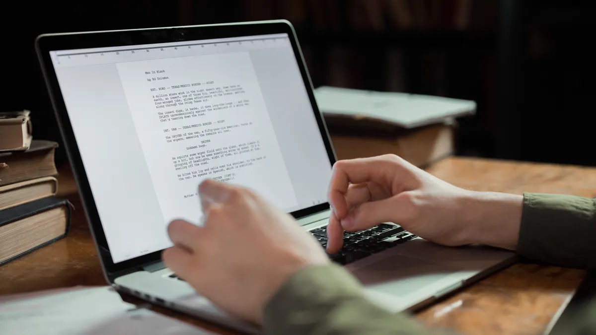 person typing a draft on a laptop