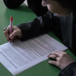 person editing a printed document with a pen
